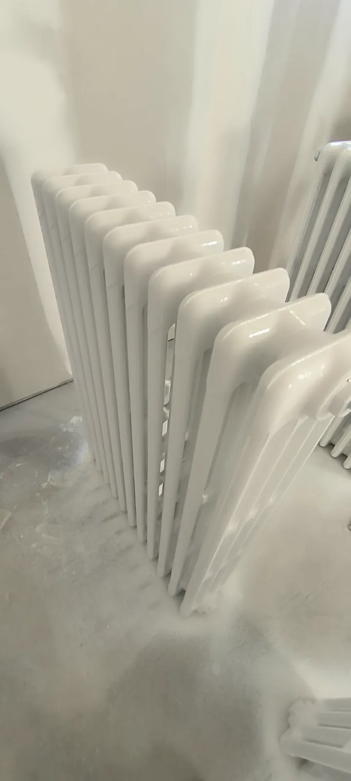 Radiateurs en fonte très sales repeints en blanc brillant au pistolet airless