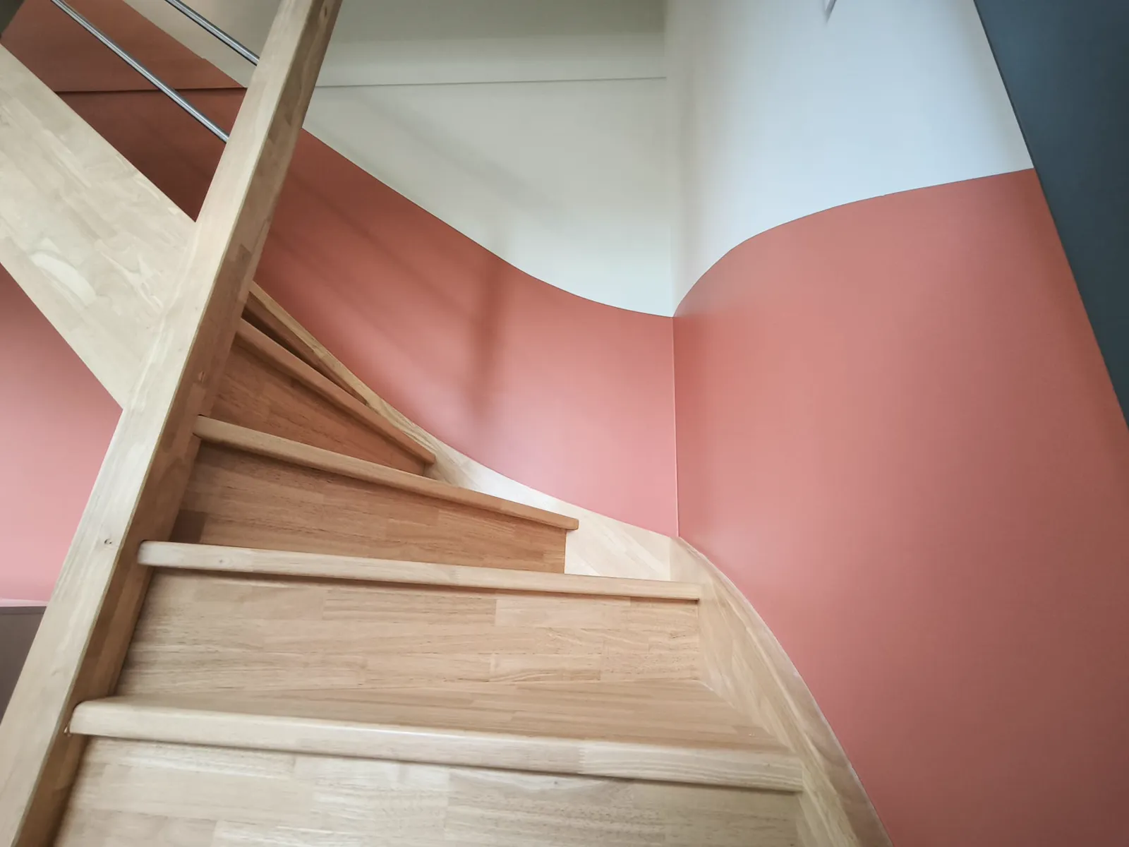 Escalier en bois avec un soubassement terracotta aux lignes courbes