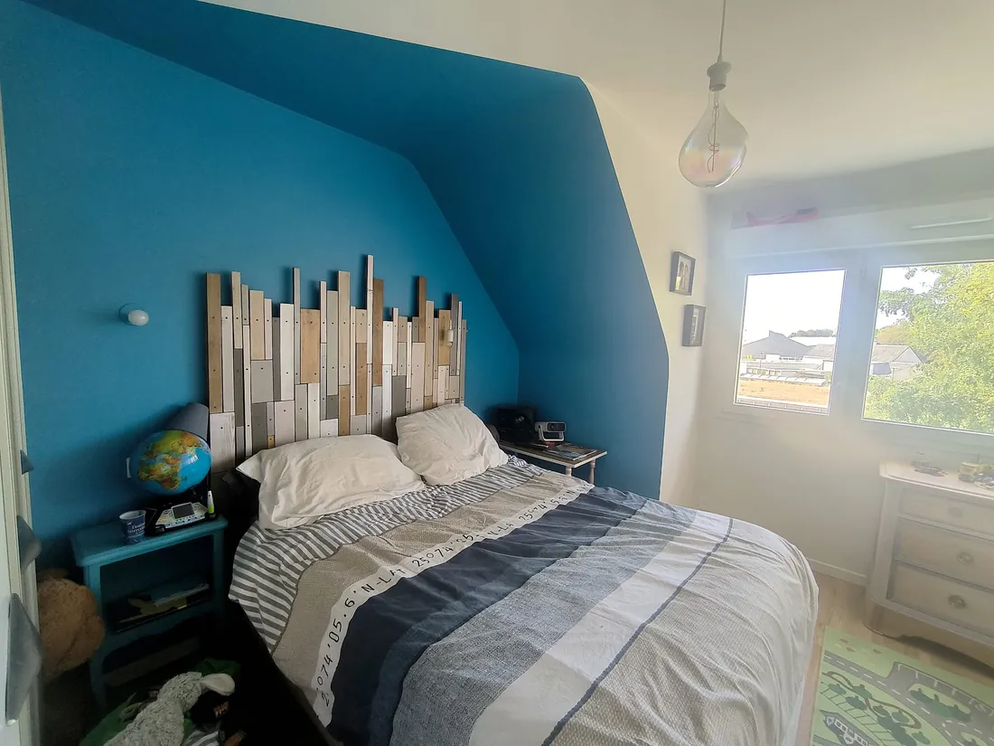 Chambre avec un mur bleu en forme de maison