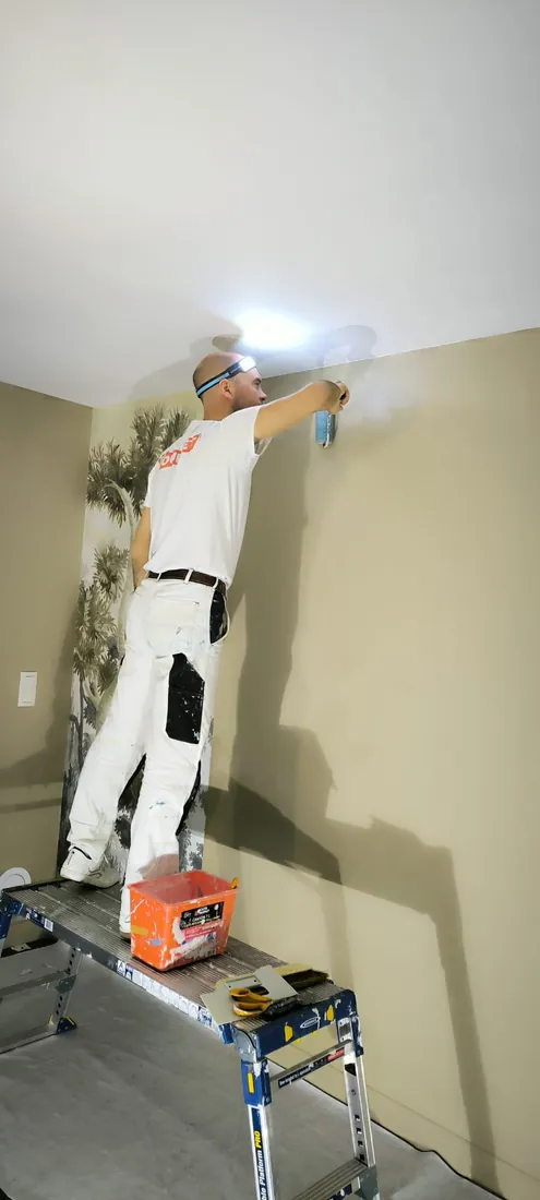 Fabien Lesure encollant un mur avant la pose d'un papier peint panoramique haut de gamme